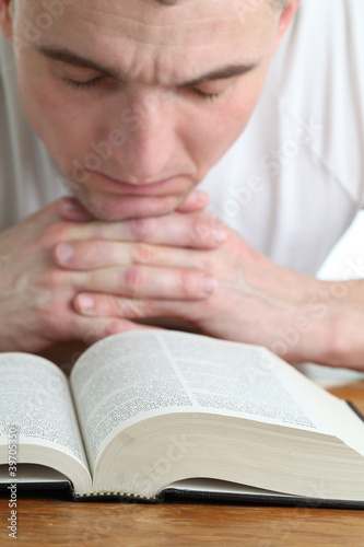 Man praying with the Bible. Focus on the Bible