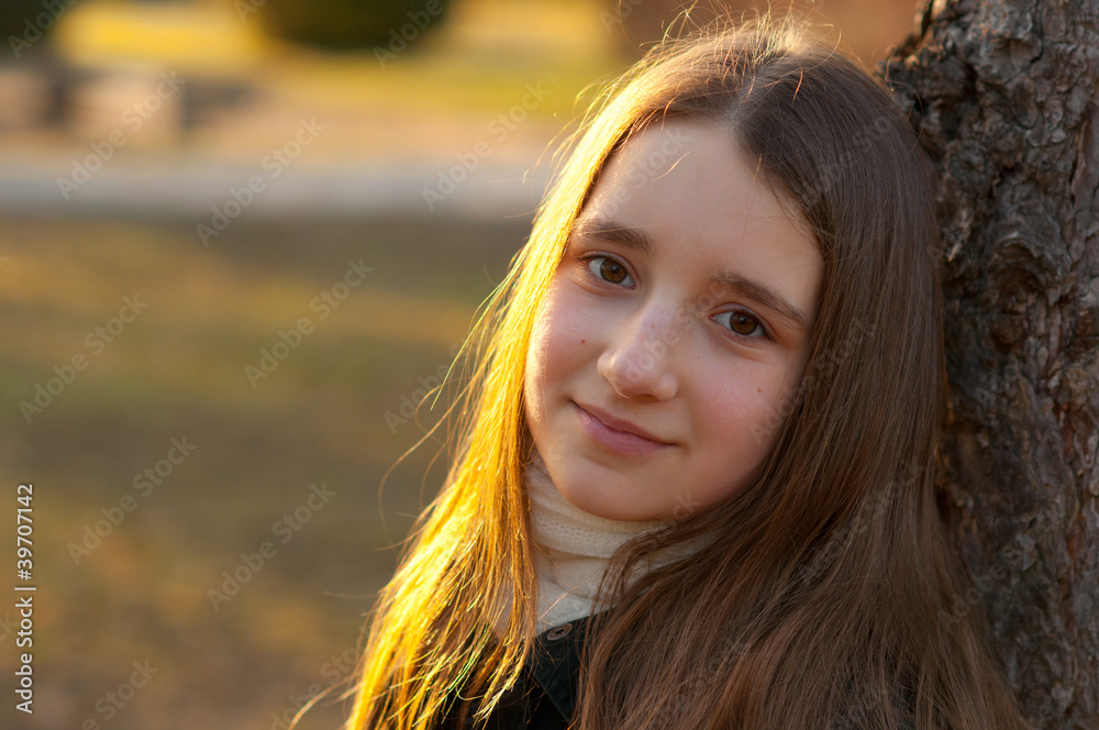 Portrait of beautiful smiling teenage girl leaning against tree Portrait of beautiful smiling teenage girl leaning against tree