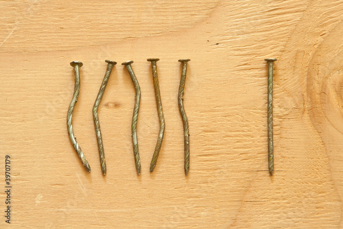 Conceptual image of crooked nails and straight nail