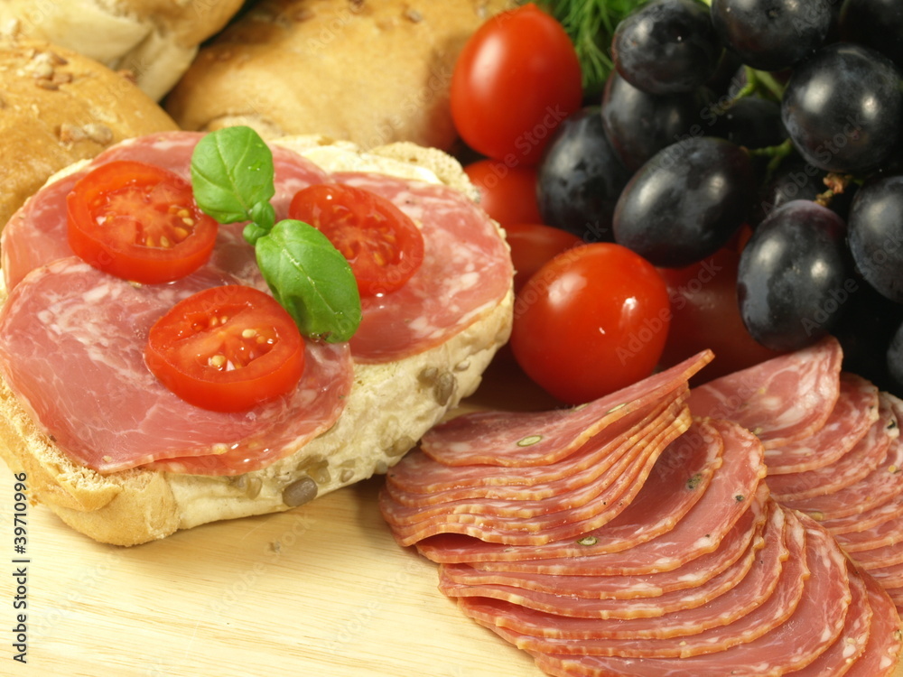 Sandwich with slices of salami and tomatoes