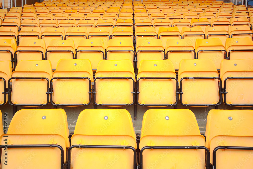 Fototapeta premium Plenty of yellow plastic seats at stadium