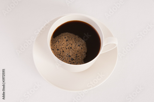 White cup filled with hot black coffee