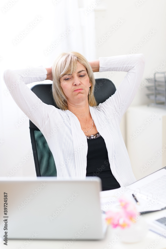 Tired senior business woman looking on computer Tired senior business woman looking on computer