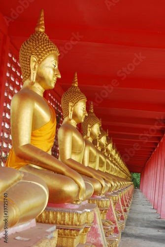 Row of seated Buddhas at the temple  of Uthai Thani, Thailand.