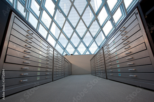 Valokuva Series of library pullout shelves against modern windows