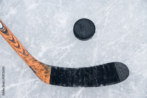 ice hockey stick and puck on ice