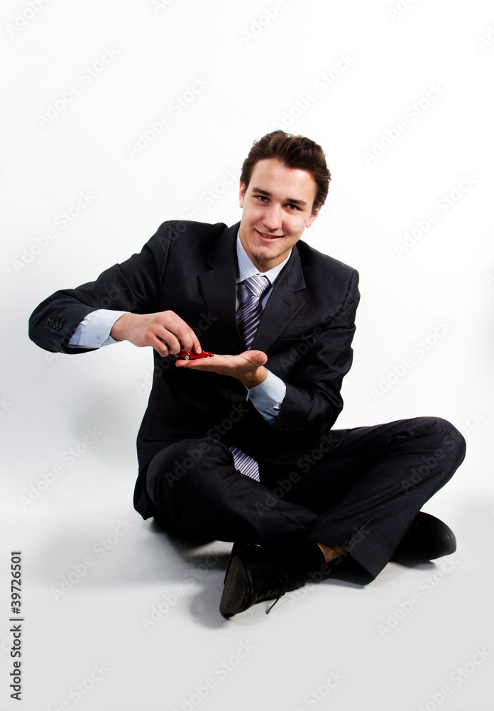 portrait of a young manager for motor with a small red toy car portrait of a young manager for motor with a small red toy car