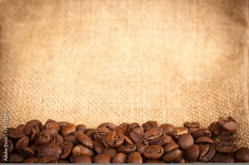 Coffee beans on burlap material © Sociologas