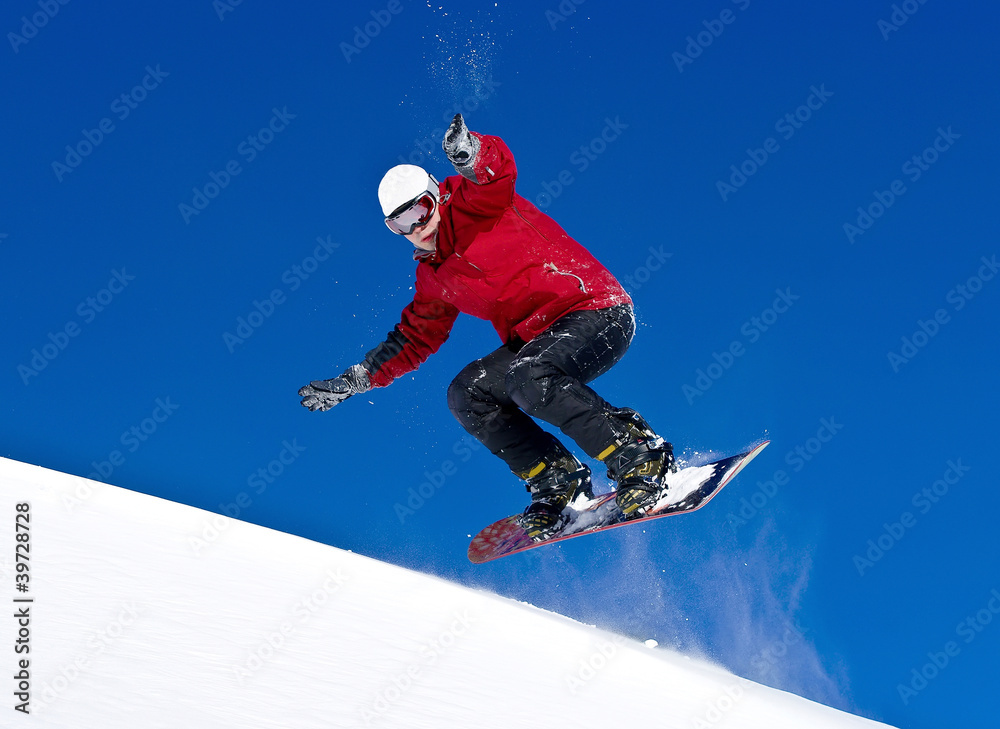 Snowboarder jumping through air with deep blue sky