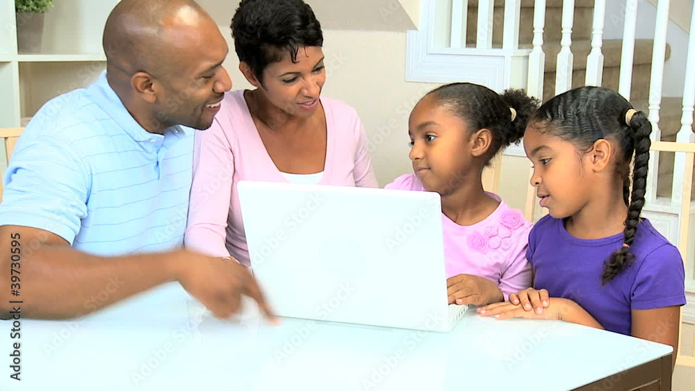 Proud Ethnic Parents Watching Daughters Using Laptop Proud Ethnic Parents Watching Daughters Using Laptop