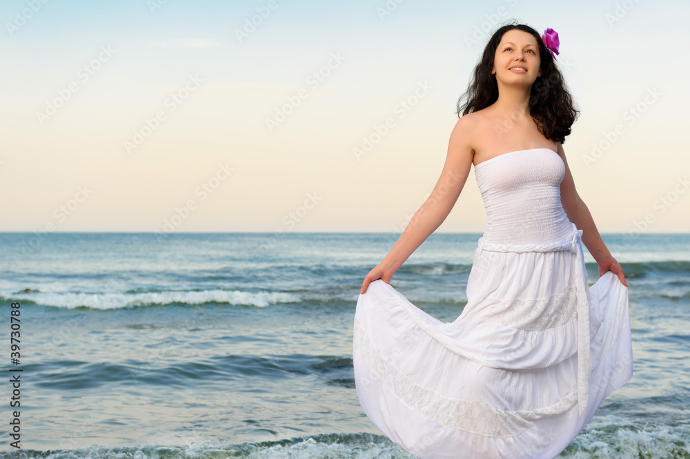 The woman in a white sundress on seacoast. The woman in a white sundress on seacoast.
