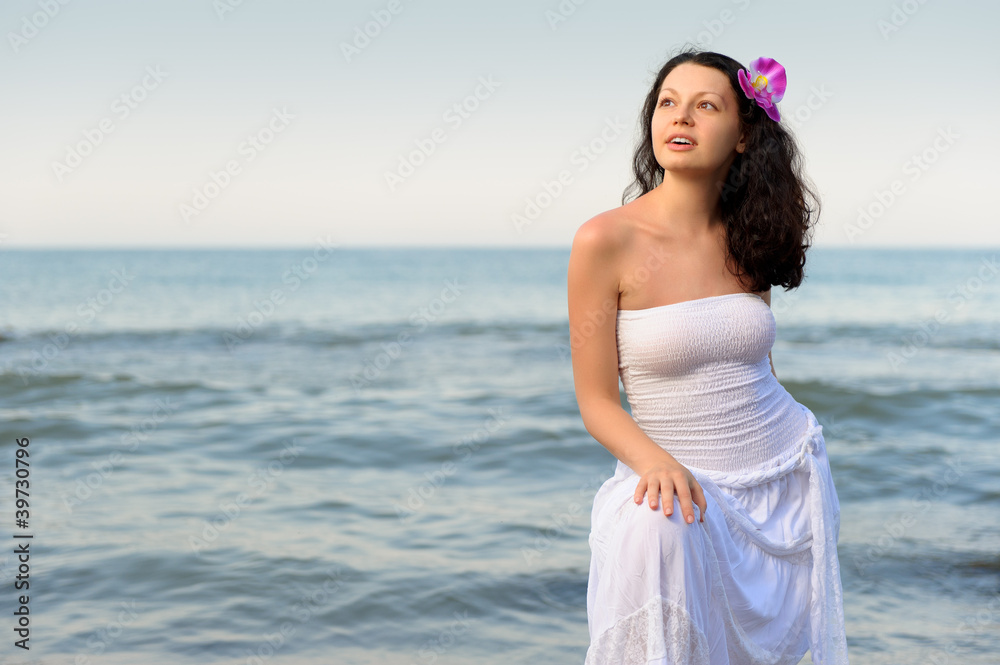 The woman in a white sundress on seacoast. The woman in a white sundress on seacoast.