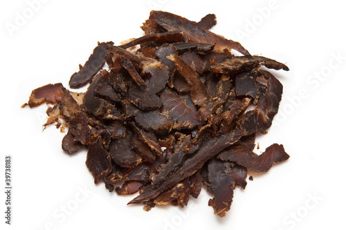 Sticed biltong (dried beef) on a white studio background.