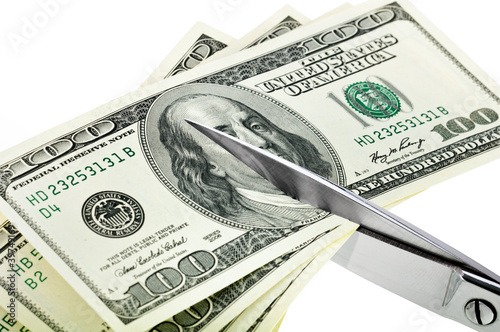 Business concept. Dollars are cutting with scissors.