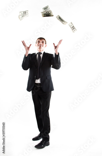 young businessman in a dark suit surrounded by flying dollars