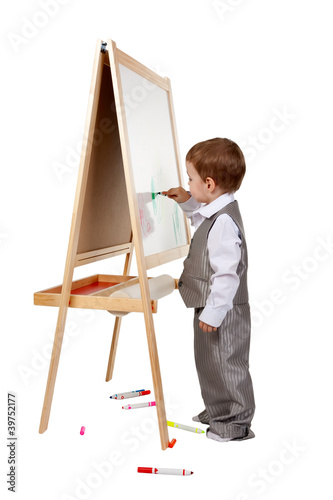 A child paints on an easel in the studio