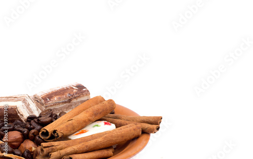 Sweets, cinnamon, nuts and coffee beans on a saucer