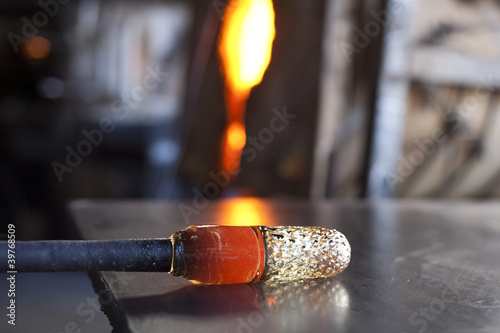 Glass blower shaping molten glass