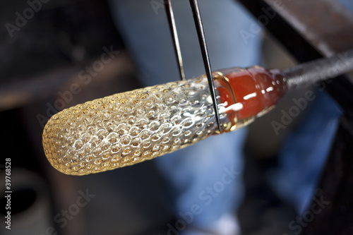Glass blower shaping molten glass