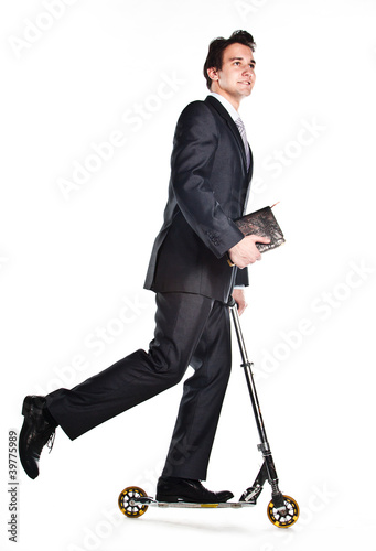 successful man in business suit who rides a scooter photo
