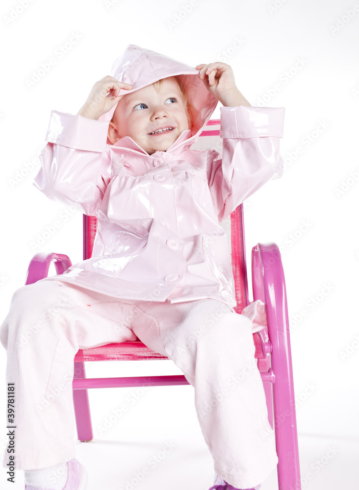 little girl wearing raincoat sitting on chair