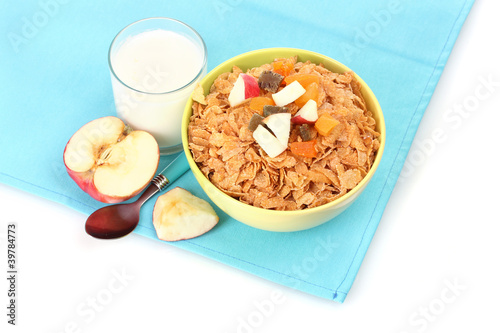 tasty cornflakes in bowl with dried fruits, glass of milk and