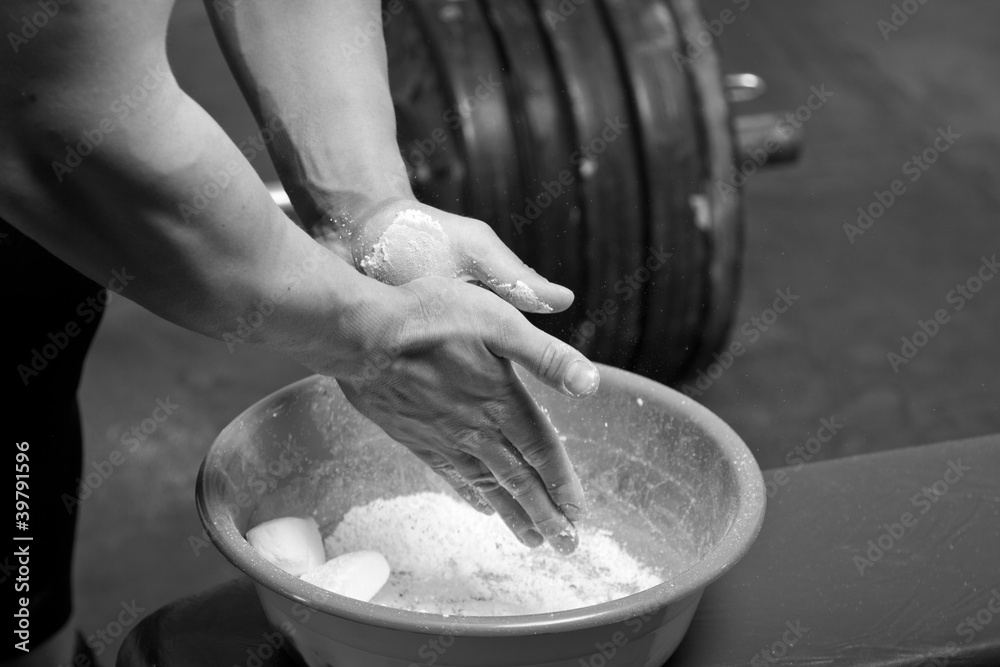 Closeup of hands of the weightlifter in talc