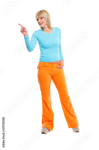 Full length portrait of elderly woman pointing in corner