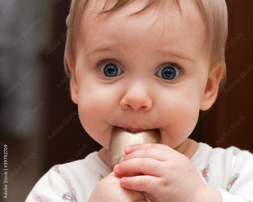 Baby girl holding spoon in mouth Baby girl holding spoon in mouth