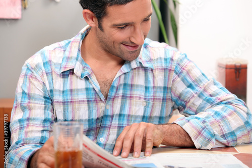 Man reading newspaper at the breakfast table