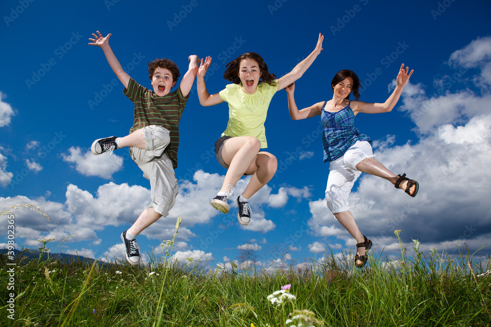 Active family - mother and kids running, jumping outdoor