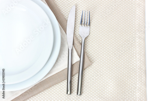 Table setting with fork, knife, plates, and napkin