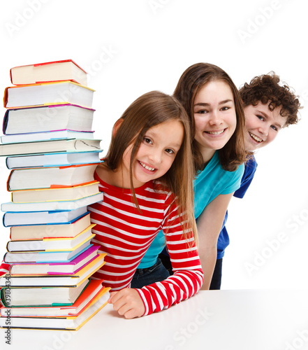 Students peeking behind pile of books on white #39804343