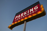 big illuminated red parking sign with many lamps orange arrow