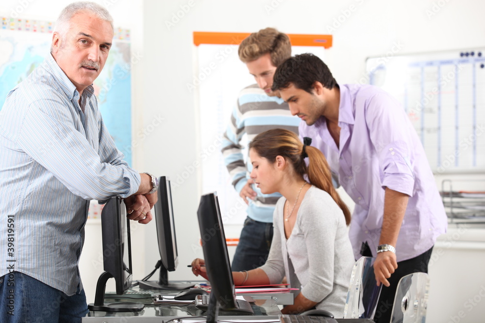 Fototapeta premium Menedżer i jego zespół pracujący przy komputerach