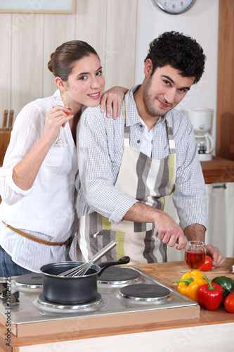 portrait of young man cooking in kitchen with girlfriend