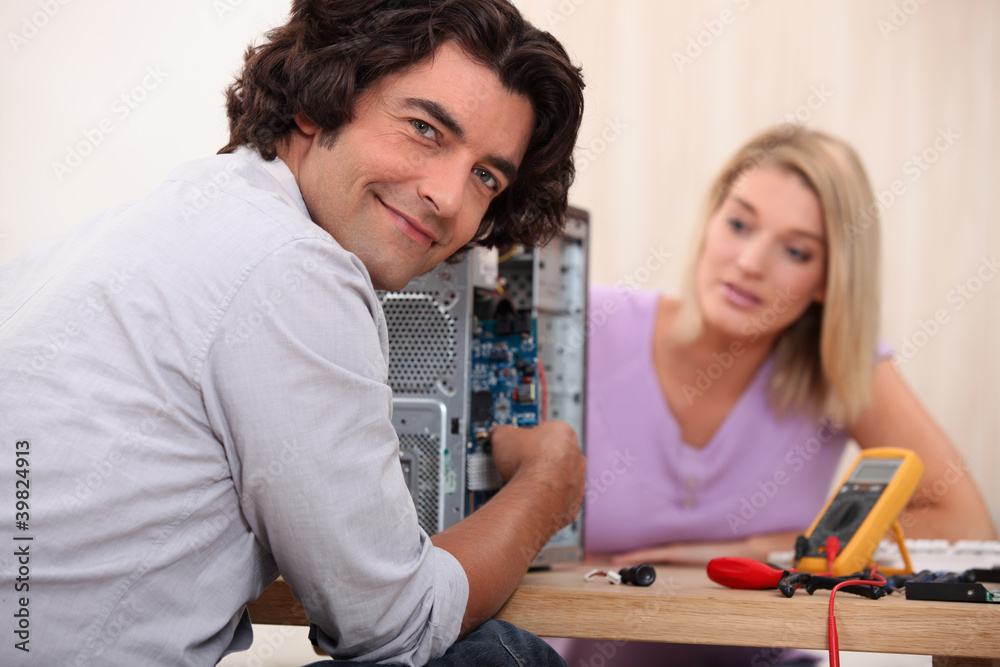 Couple repairing computer Couple repairing computer