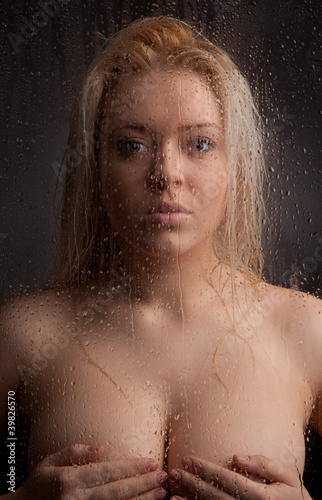 Naked girl in a wet glass on a black background