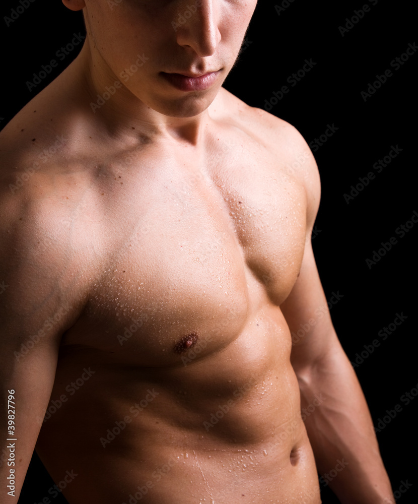 Fototapeta premium torso of young muscular man, isolated on black background