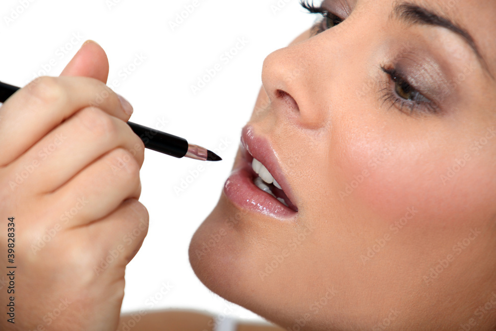 A woman putting make-up on.