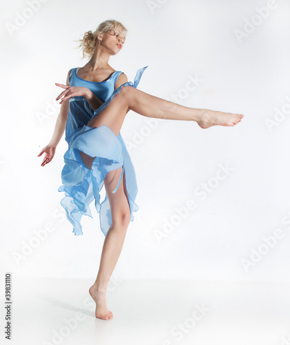 Wellness. Beautiful sexy slim woman dancing in cyan dress