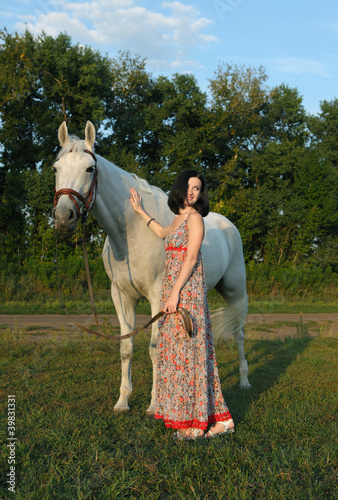 Girl with horse taking a walk in summer evening