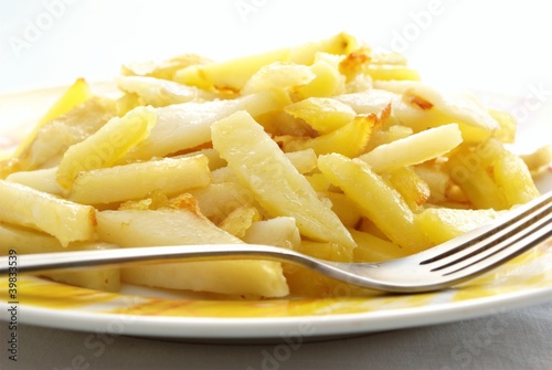 Fried potato in a plate and fork