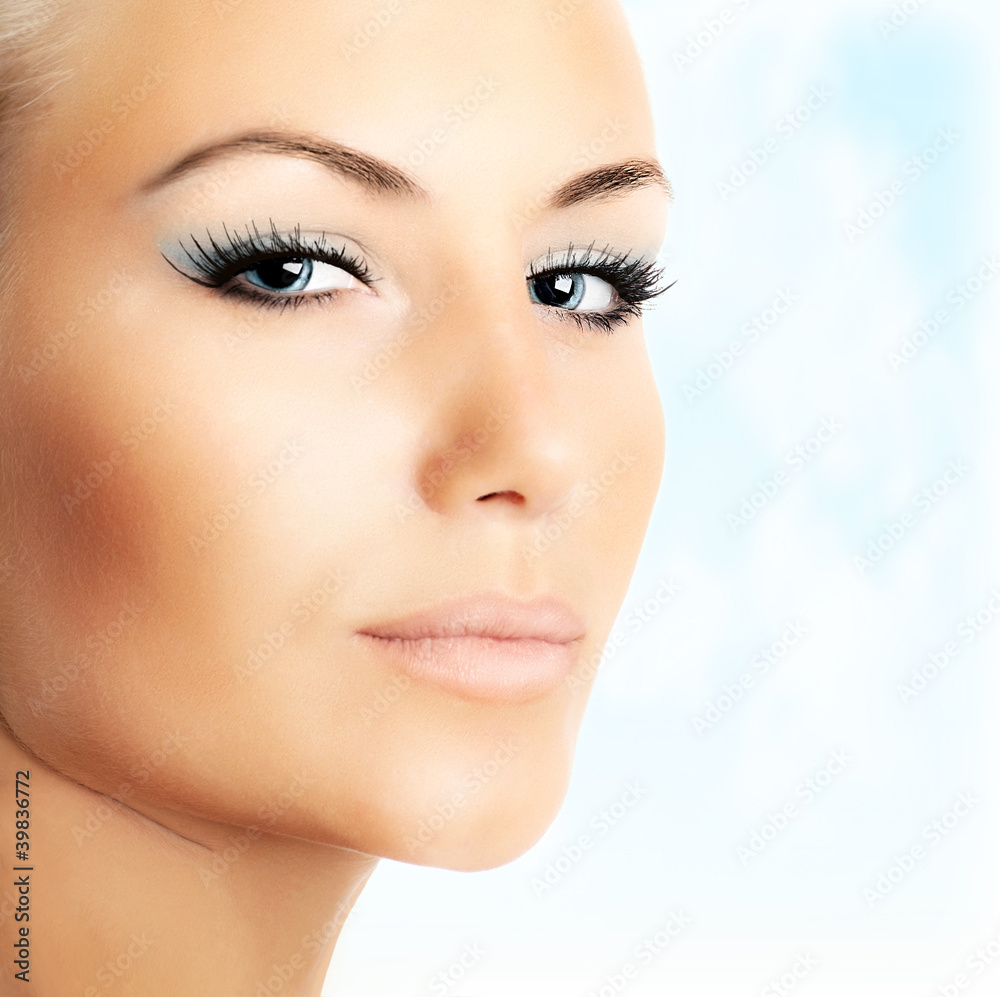 Obraz premium Beautiful female face over abstract blue sky background