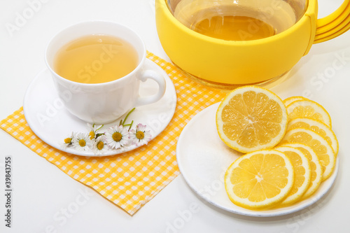 Tea with lemon and yellow roses on a white background