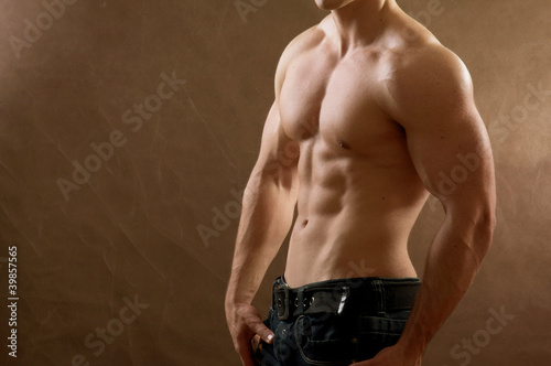 Obraz na plátně Muscular man , isolated on brown background