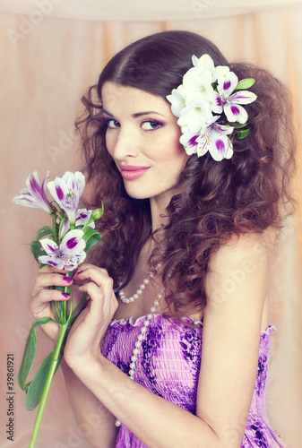 Portrait of the young, beautiful brunette in a lilac dress and w