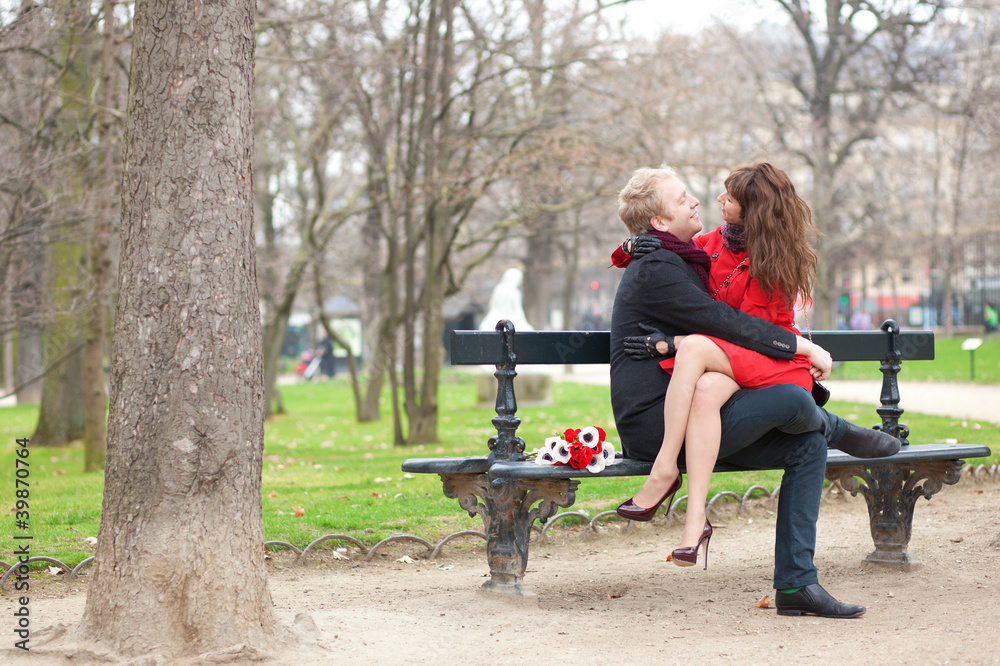 Happy romantic couple hugging on a bench Happy romantic couple hugging on a bench