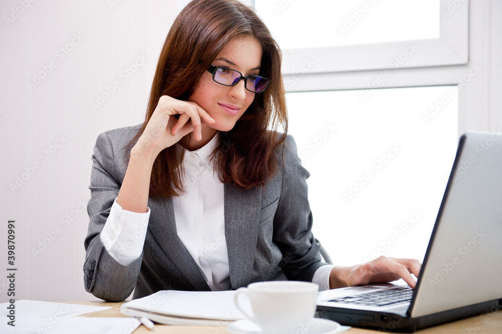 Business woman working on computer at her office Business woman working on computer at her office