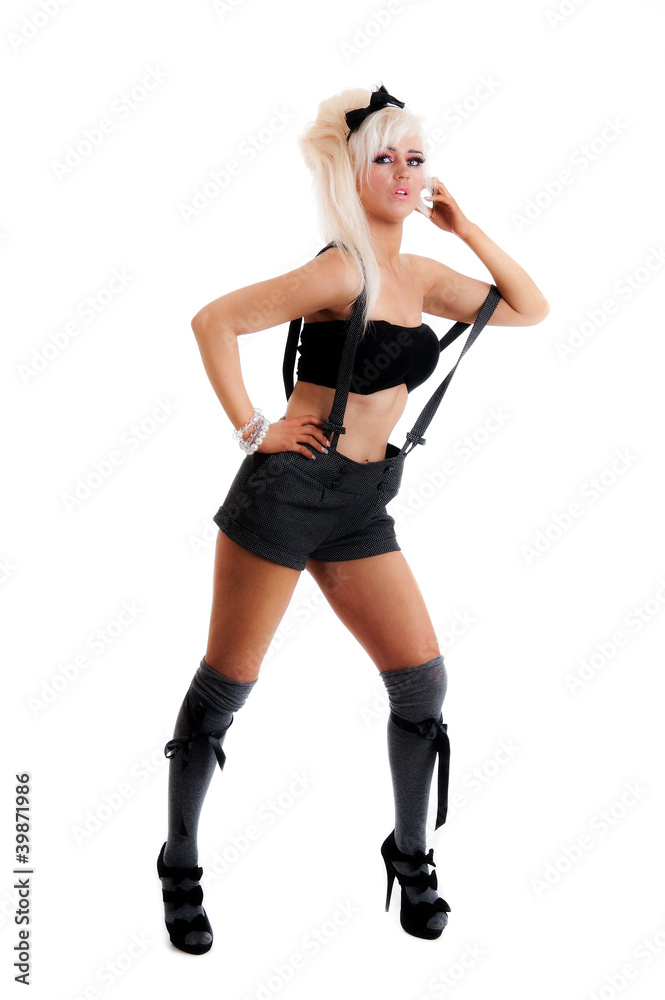 Sexy female in shorts braces and heels isolated against white Sexy female in shorts braces and heels isolated against white